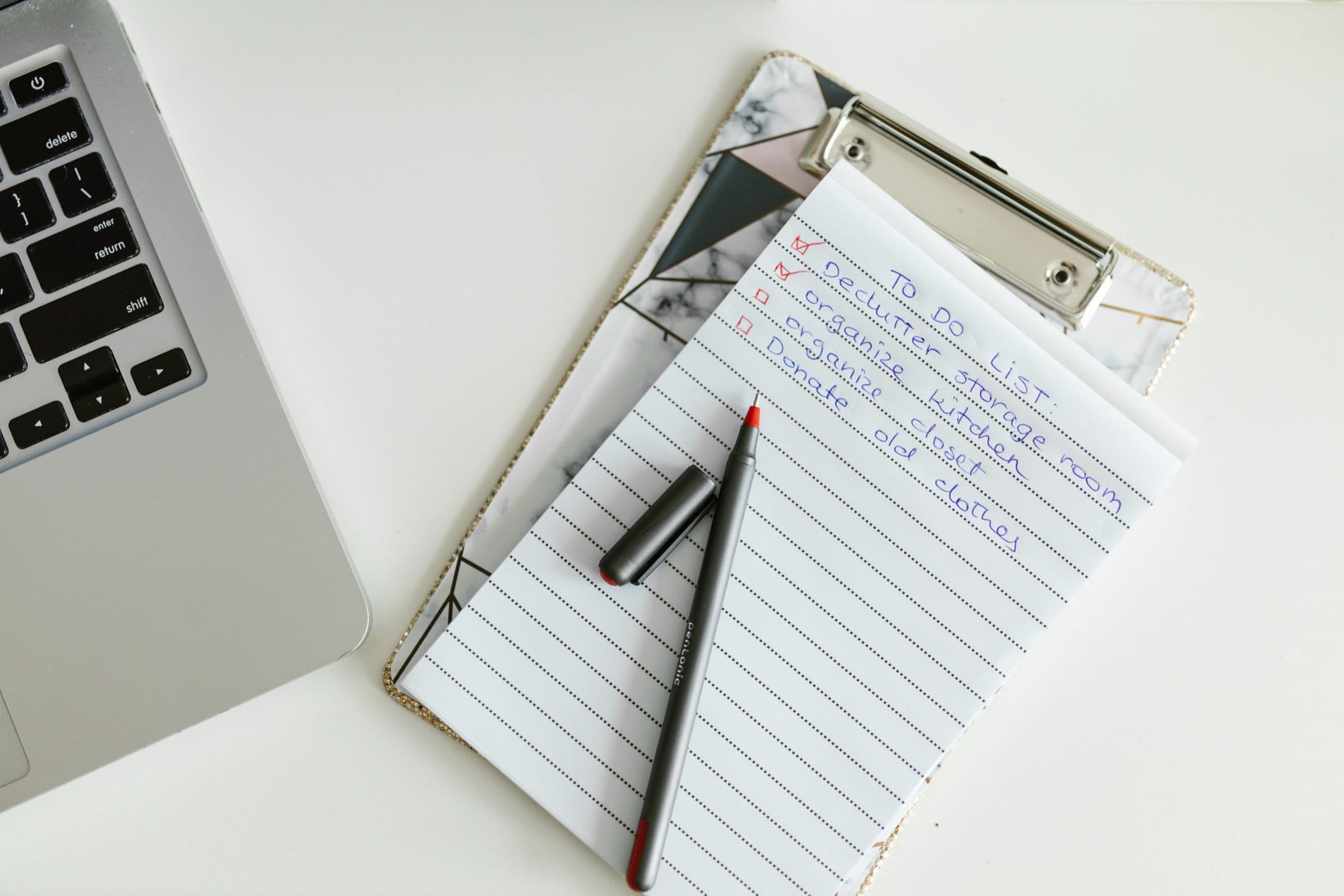 Een te doen lijst op een klipboard naast een laptop en een pen