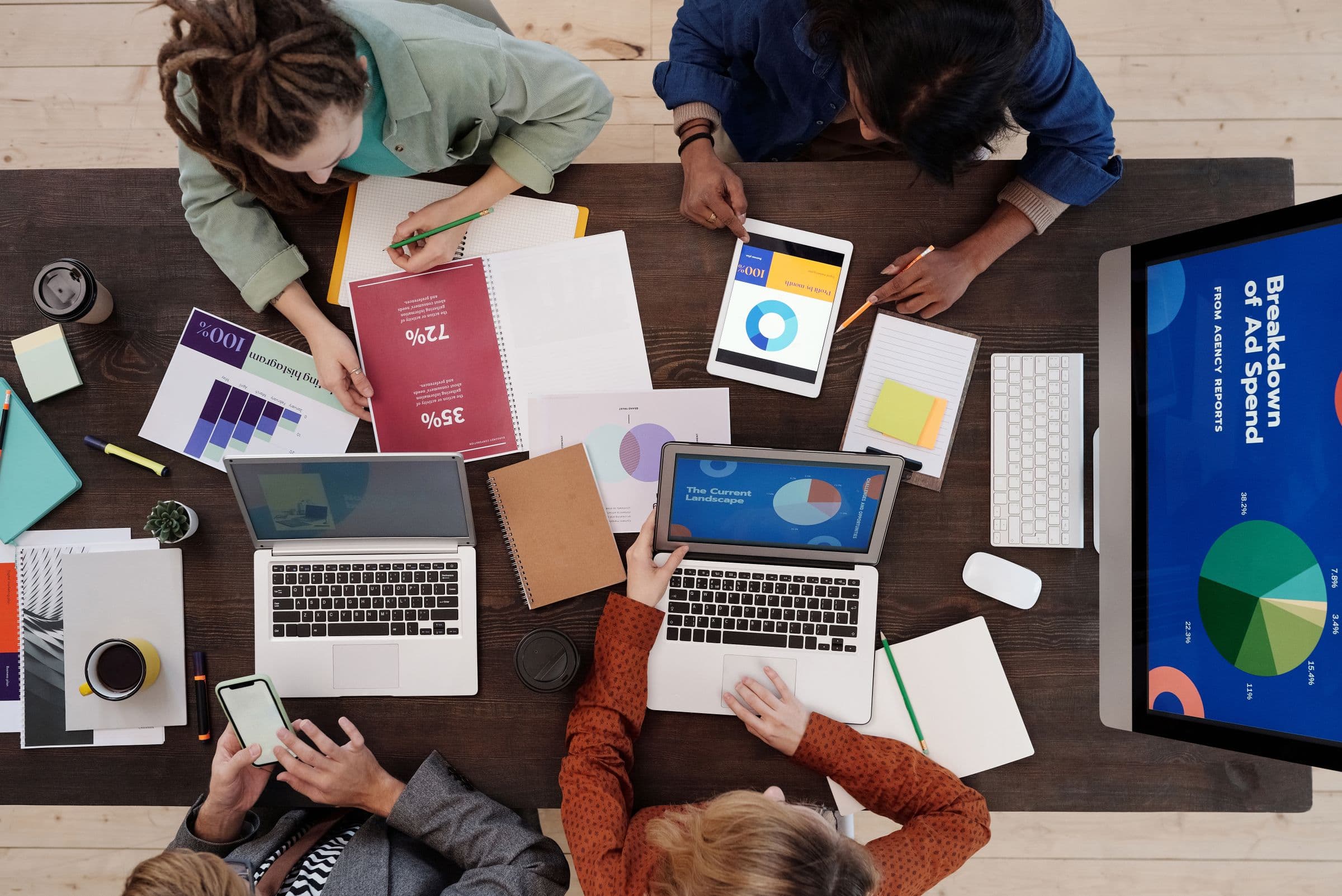 Een team dat een digitale marketingcampagne plande rond een bureau met laptops